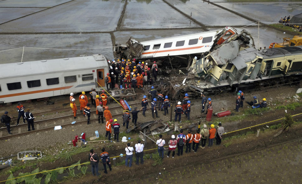 Rescuers inspect the wreckage after a collision between two trains in Cicalengka, West Java, Indonesia, Friday, Jan. 5, 2024. The trains collided on Indonesia's main island of Java on Friday, causing several carriages to buckle and overturn, officials said. (AP Photo/Achmad Ibrahim)