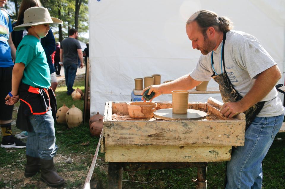 Jack Moses watches as Steve Miller forms clay into vessels at the Kentuck Festival of the Arts in Kentuck Park on Oct. 21, 2017.