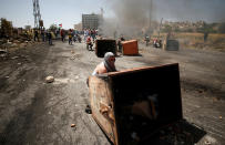 <p>Palestinian protesters take cover during clashes with Israeli troops at a protest marking the 69th anniversary of Nakba, near the Jewish settlement of Beit El, near the West Bank city of Ramallah May 15, 2017. (Photo: Mohamad Torokman/Reuters) </p>