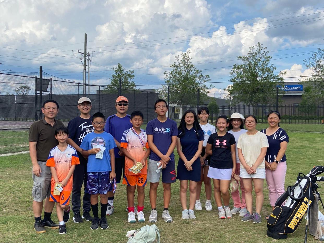 Yao Dai, third person from the left, has served as principal of the Huagen Chinese School in Gainesville for years. There, a group of teachers, volunteers and about 150 students gather on Sundays for Chinese language classes and recreational activities, such as golf.
