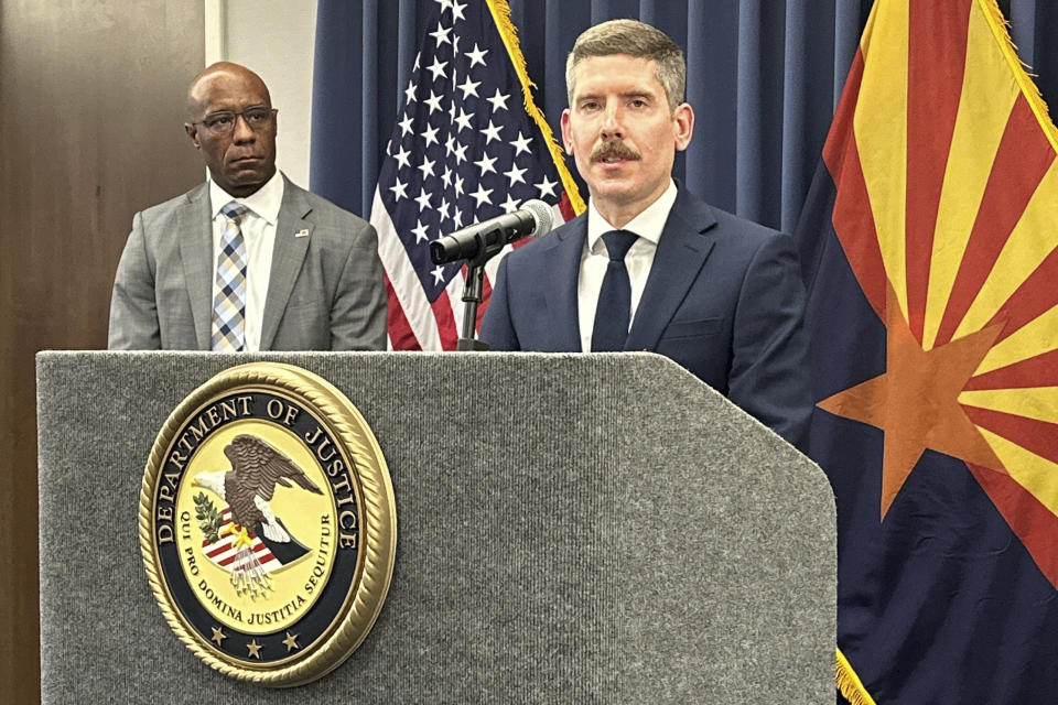 John Keller, who leads the U.S. Justice Department’s Election Threats Task Force, speaks as Akil Davis, left, special agent in charge of the FBI's Phoenix field office, listens during a news conference Monday, March 25, 2024, in Phoenix, on efforts to hold people accountable for threatening election workers. Earlier in the day, Joshua Russell of Bucyrus, Ohio, was sentenced in Phoenix to 2 1/2 years in prison for his conviction for making threats against then-Arizona Secretary of State Katie Hobbs, who is now the state's governor. (AP Photo/Jacques Billeaud)