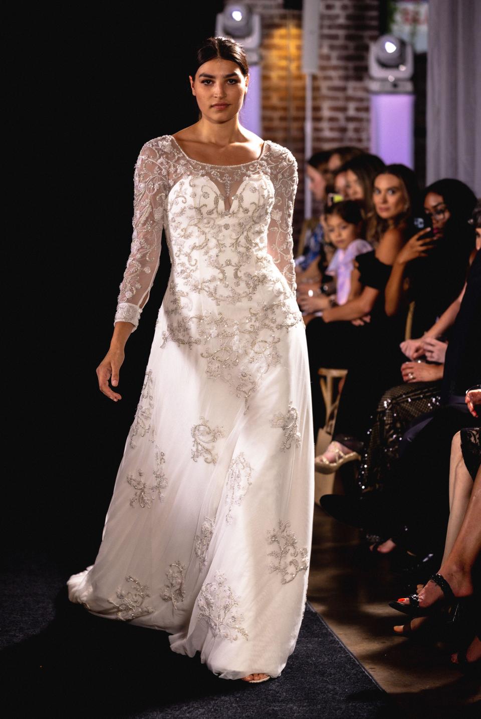 Wedding dress with sheer sleeves and intricate details.