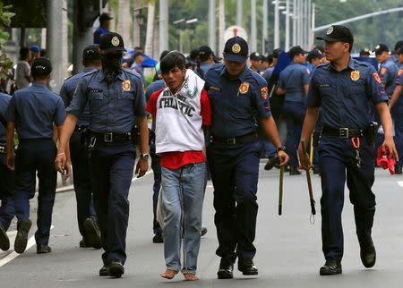 Policemen detain a demonstrator after a violent dispersal of various activist and Indigenous People's (IP) groups protesting against the continuing presence of U.S. troops in the Philippines in front of the U.S. Embassy in metro Manila. REUTERS/Romeo Ranoco