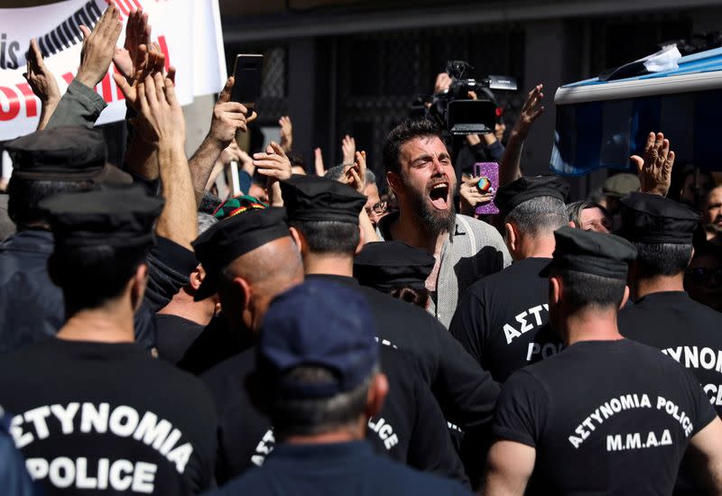 Turkish Cypriots shout slogans at the Ledra checkpoint of the U.N.-controlled buffer zone, after authorities declared the crossing temporarily shut to curb any potential spread of coronavirus, in Nicosia