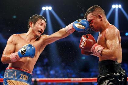 Zou Shiming delivers a punch to Colombian boxer Luis De La Rosa on July 19, 2014. (AP)