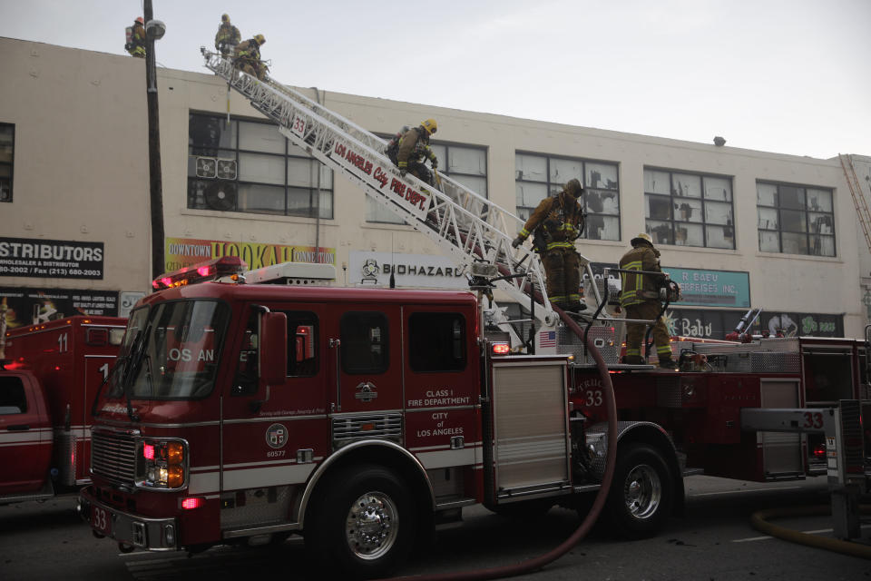 Los Angeles Fire Department firefighters work the scene of a structure fire that injured multiple firefighters, according to a fire department spokesman, Saturday, May 16, 2020, in Los Angeles. (AP Photo/Damian Dovarganes)