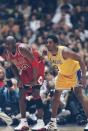 Michael Jordan and a young Kobe Bryant during a Bulls-Lakers game in the 1997-98 season. (Getty Images)