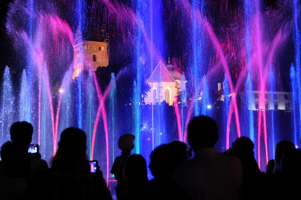 This Aug. 3, 2013 photo shows people watching a fountain light and music show taking place on the weekends in the summer in Rybaki street near the Old Town in Warsaw, Poland. (AP Photo/Alik Keplicz)