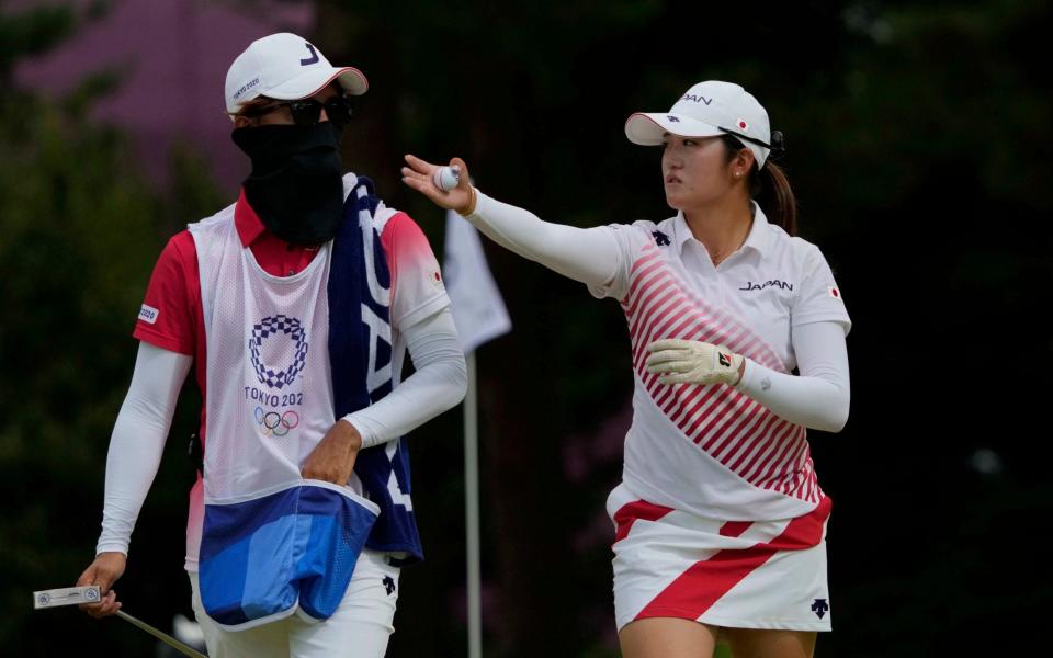 Mone Inami, of Japan, speaks with her caddie on the second hole during the final round of the women's golf event  - AP Photo/Andy Wong