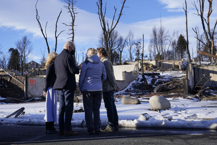 President Joe Biden and first lady Jill Biden talk with people as they tour a neighborhood in Louisville, Colo., Friday, Jan. 7, 2022, that was impacted by the recent wildfire. (AP Photo/Susan Walsh)