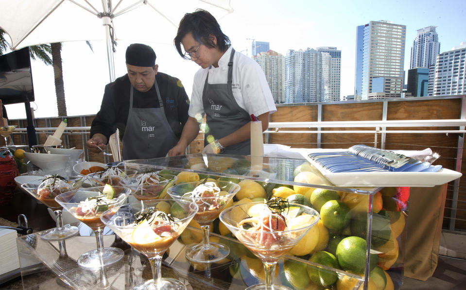 Richard Bernaola, left, and Executive Chef Diego Oka for the LeMar by Gaston Acurio cafe create ceviche dishes for the launching of the Mandarin Oriental hotel's newest cafe in Miami, Wednesday, Dec. 18, 2013. He has been called the unofficial ambassador of Peruvian cuisine, but chef Acurio prefers to share that title with his fellow countrymen. With some 40 restaurants across the world, from Madrid to Miami, Acurio is undoubtedly the face of Peruvian cuisine. His flagship restaurant, Astrid&Gaston, was ranked 14 on this year’s World’s 50 Best Restaurants and his latest spot, La Mar at the Mandarin Oriental in Miami, is scheduled to launch in February. (AP Photo/J Pat Carter)