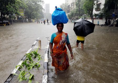 People wade through a waterlogged street during heavy rains in Mumbai, July 8, 2018. REUTERS/Danish Siddiqui