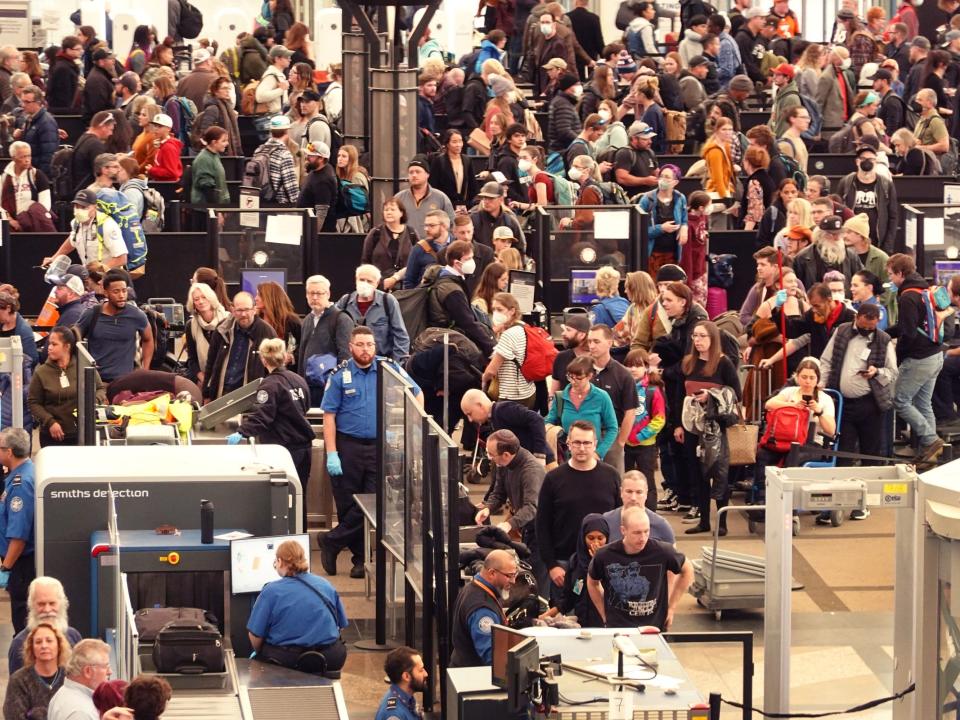 Travelers navigate a security checkpoint at Denver International Airport on November 22, 2022 in Denver ahead of the Thanksgiving holiday.