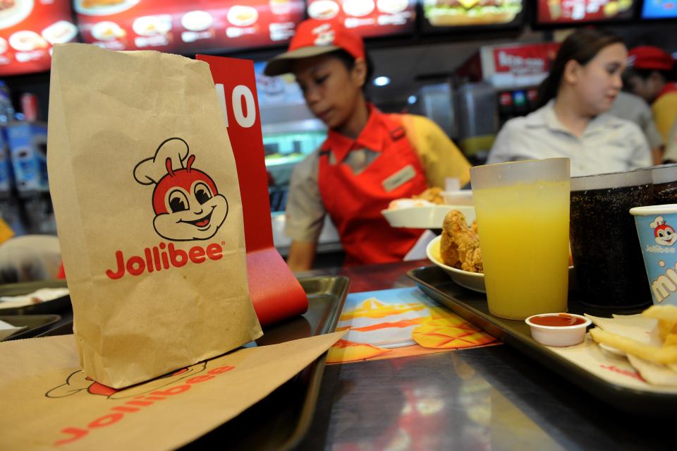 Philippines' leading fast-food giant Jollibee Foods employees attend to customer orders at a Jollibee store in Manila on October 14, 2015. Jollibee Foods announced on October 13 it had acquired 40 percent of an upmarket US hamburger chain for 99 million USD.      AFP PHOTO / Jay DIRECTO        (Photo credit should read JAY DIRECTO/AFP/Getty Images)