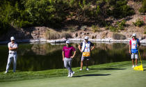 Matthew Wolff, left, and Tyrrell Hatton, second from left, watch as Jon Rahm (not shown) putts on the fourth green during the first round of the CJ Cup golf tournament at Shadow Creek Golf Course, Thursday, Oct. 15, 2020, in North Las Vegas. (Chase Stevens/Las Vegas Review-Journal via AP)