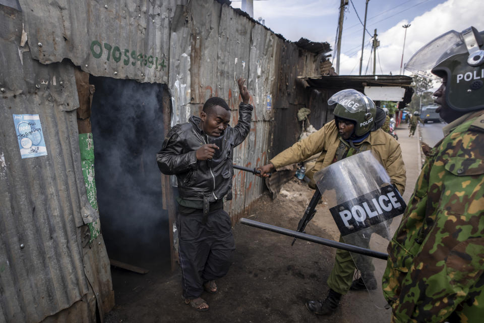 Police beat a protester who had hidden in a shack, after police threw a tear gas grenade inside to force him out, in the Kibera slum of Nairobi, Kenya Monday, March 20, 2023. Hundreds of opposition supporters have taken to the streets of the Kenyan capital over the result of the last election and the rising cost of living, in protests organized by the opposition demanding that the president resigns from office. (AP Photo/Ben Curtis)