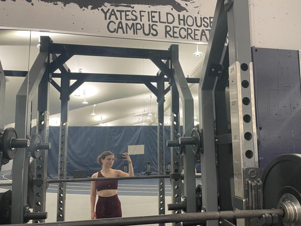 Emma Ginsberg taking a mirror selfie in the gym