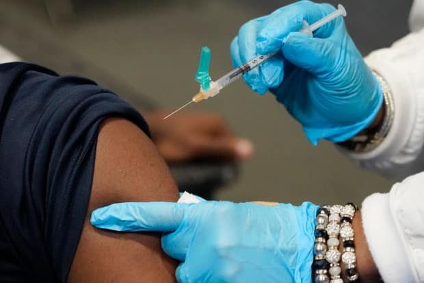 About 75.7 per cent of the eligible population in Alberta has received at least one dose of a COVID-19 vaccine. (Rogelio V. Solis/The Associated Press - image credit)