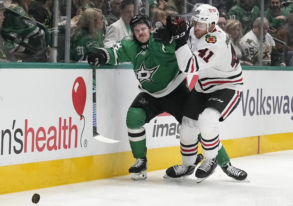 Chicago Blackhawks defenseman Isaak Phillips (41) crashes Dallas Stars center Joe Pavelski (16) into the boards during the first period of an NHL hockey game in Dallas, Friday, Dec. 29, 2023. (AP Photo/LM Otero)