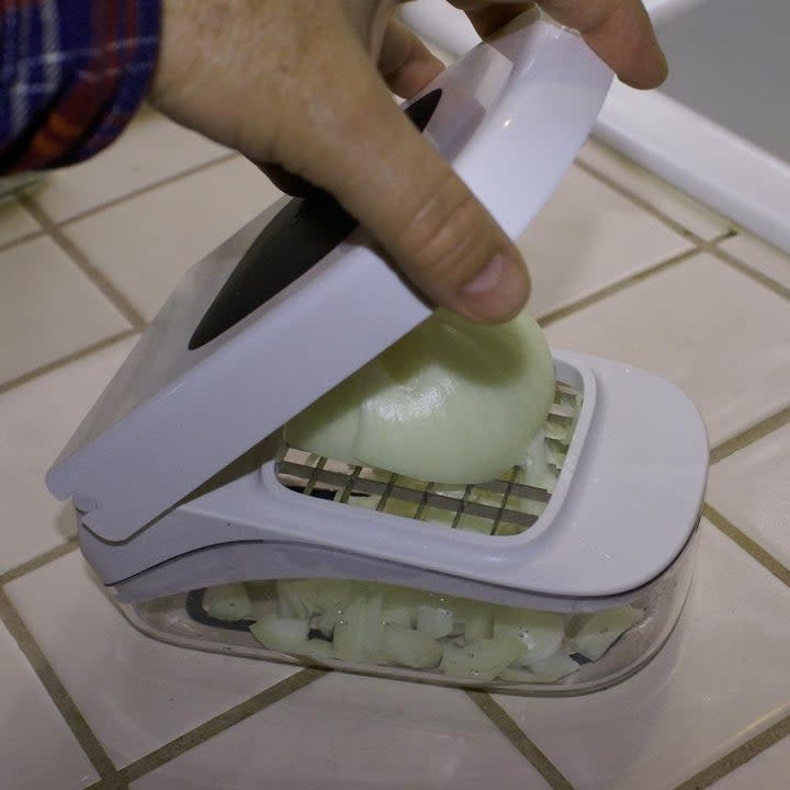 reviewer using compact chopper to dice an onion