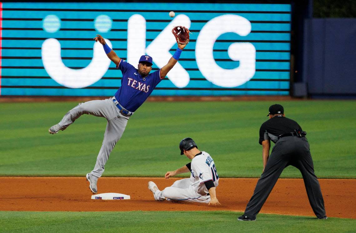 Texas Rangers second baseman Ezequiel Duran (70) jumps to catch the baseball as Miami Marlins second baseman Joey Wendle (18) steals second base during the first inning of a baseball game at LoanDepot Park on Thursday, July 21, 2022 in Miami, Florida.