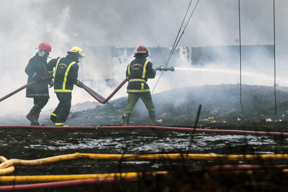 Firefighters work to put out a deadly fire at a large oil storage facility in Matanzas, Cuba, Tuesday, Aug. 9, 2022. The fire was triggered when lighting struck one of the facility's eight tanks late Friday, Aug. 5th. (Yamil Lage, Pool photo via AP)