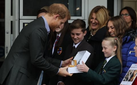 Harry is presented with a Passchendaele 100 Poppy Pin by 11 year old Phoebe Taylor from Shakespeare primary school in Fleetwood  - Credit: Owen Humphreys/PA Wire