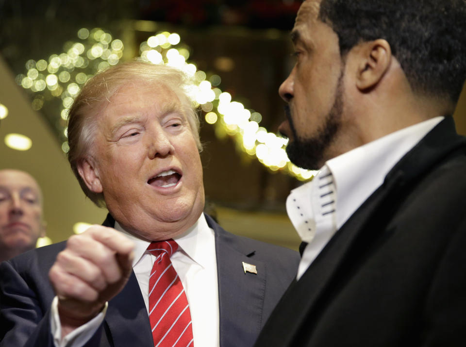 FILE - In this Nov. 30, 2015 file photo, then Republican presidential candidate Donald Trump, left, talks to Pastor Darrell Scott while surrounded by reporters in New York. On Sunday, Jan. 10, 2021, the first day of Christian worship services since the Capitol riot, religious leaders who have supported the president in the past delivered messages ranging from no mention of the events of that day to incendiary recitations of debunked conspiracy theories.(AP Photo/Seth Wenig, File)