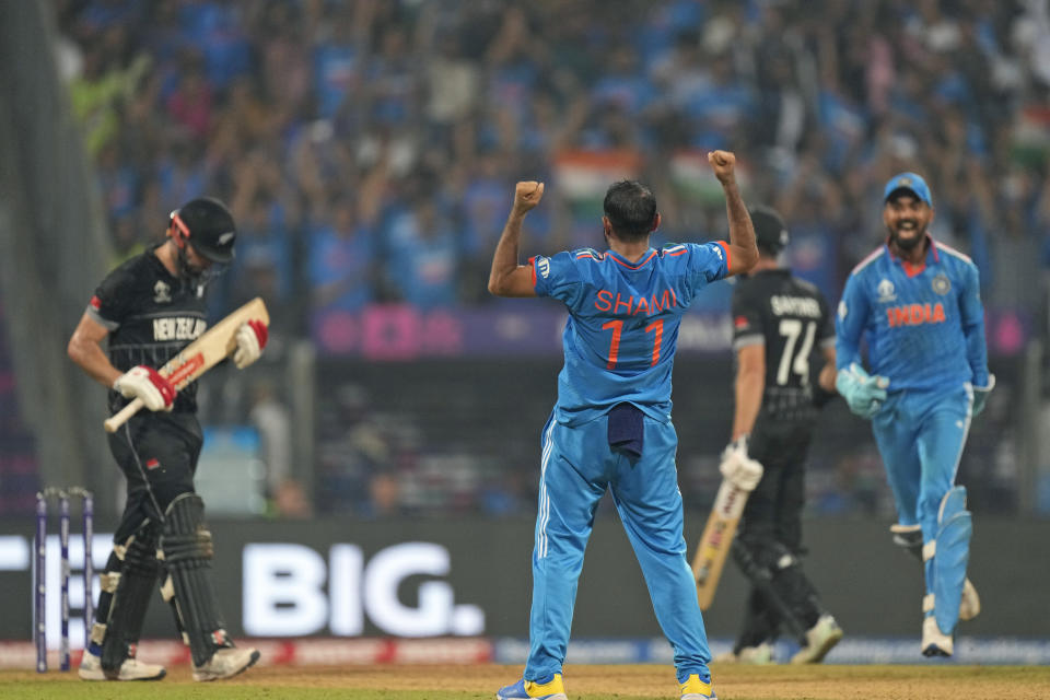 India's Mohammed Shami celebrates the wicket of New Zealand's Daryl Mitchell, left, during the ICC Men's Cricket World Cup first semifinal match between India and New Zealand in Mumbai, India, Wednesday, Nov. 15, 2023. (AP Photo/Rajanish Kakade)