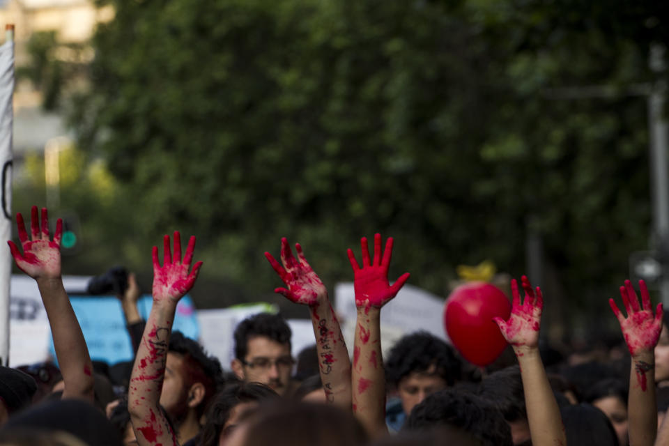 Women in Santiago show their hands stained with red paint on October 19.