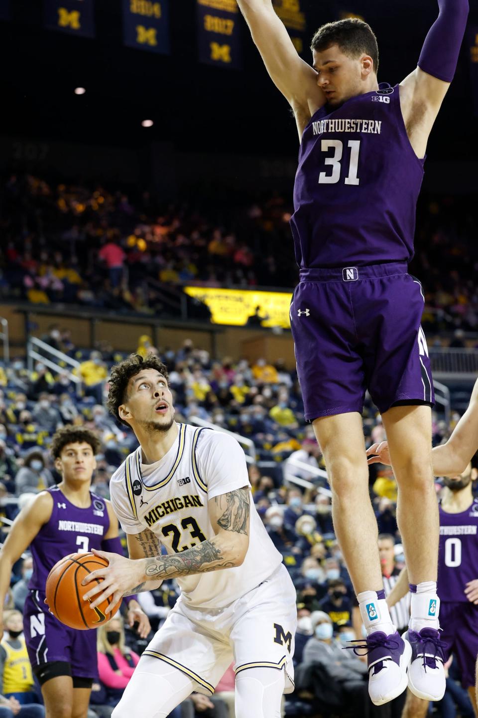 Michigan Wolverines forward Caleb Houstan (22) is defended by Northwestern Wildcats forward Robbie Beran (31) in the first half at Crisler Center on Jan. 26, 2022.