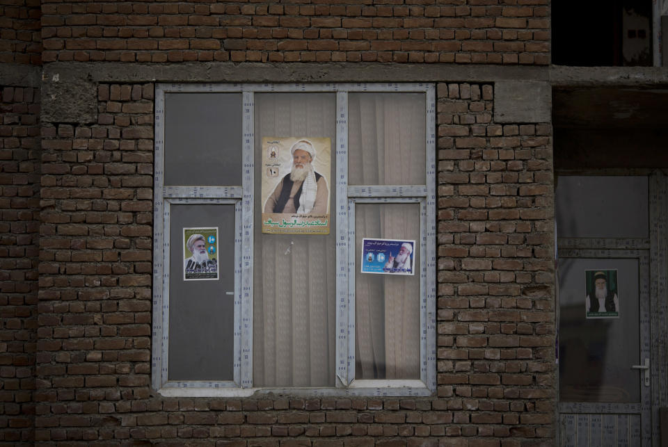 In this Friday, March 7, 2014 photo, election posters with presidential hopeful Abdul Rasoul Sayyaf are decorated in a window of a house in Kabul, Afghanistan. During Afghanistan’s civil war in the early 1990s, Sayyaf’s militia killed tens of thousands of Hazaras, a community who are mostly Shiite Muslims, considered infidels by the Sunni radical fighters in Sayyaf’s forces. Still, many of the candidates or their running mates have violent histories. Several have been named by the U.S.-based Human Rights Watch as responsible for mass killings during the 1992 to 1996 civil war, fought between Islamic insurgents turned warlords who turned their guns on each other after throwing out the invading Soviet military. (AP Photo/Anja Niedringhaus)