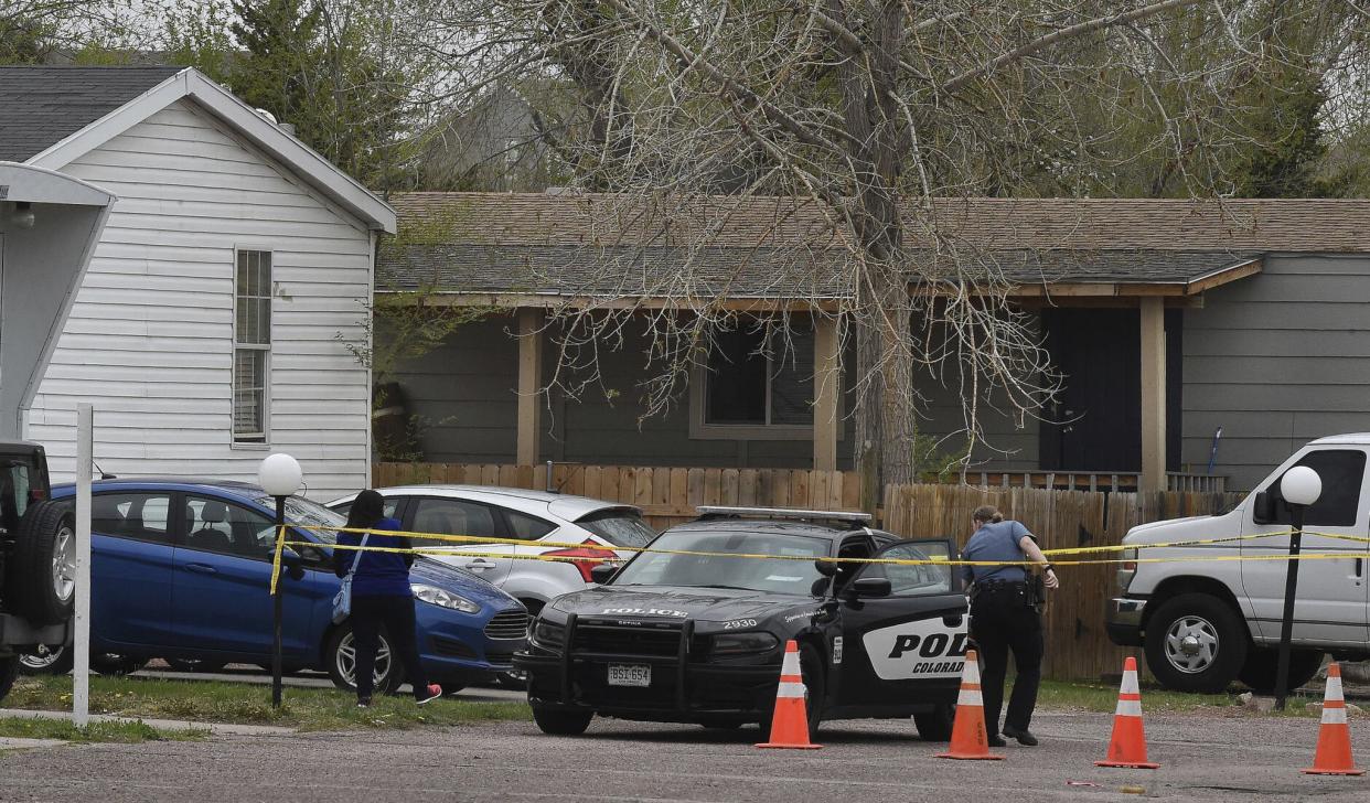 A Colorado Springs police officer goes to help a person who was in a different mobile home to be able to get to her car from behind the crime tape in Colorado Springs, Colo., Sunday, May 9. 