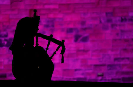 FILE PHOTO: A piper plays a tune at Edinburgh Castle to herald the New Year during the Hogmanay celebrations in Edinburgh, Scotland, January 1, 2018. REUTERS/Russell Cheyne/File Photo