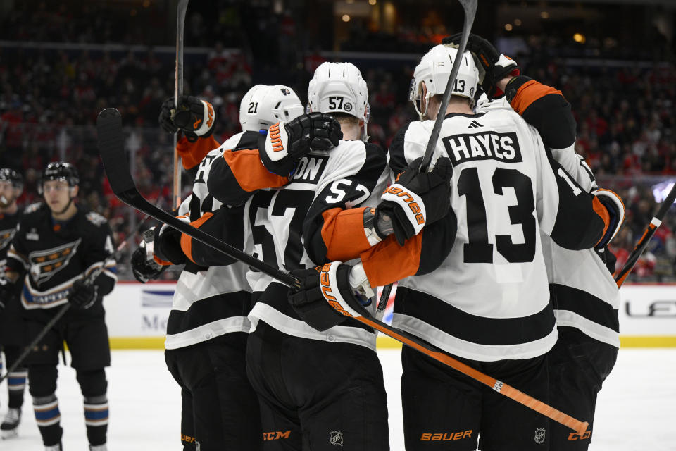 Philadelphia Flyers right wing Wade Allison (57) celebrates his goal against the Washington Capitals with center Kevin Hayes (13) and others during the second period of an NHL hockey game Saturday, Jan. 14, 2023, in Washington. (AP Photo/Nick Wass)