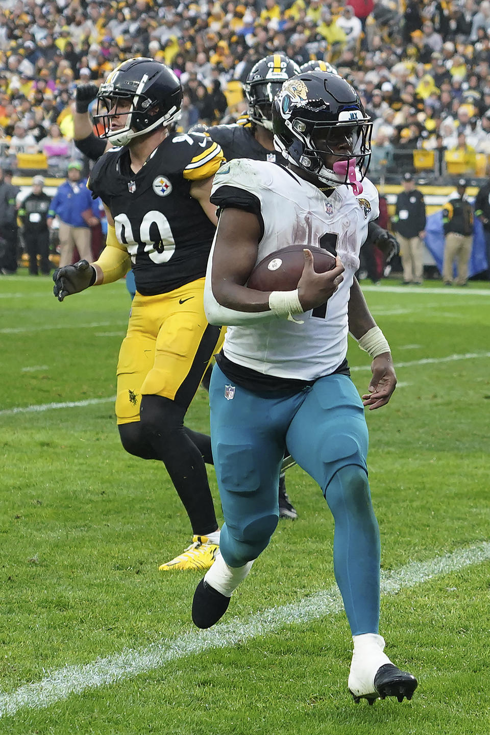 Jacksonville Jaguars running back Travis Etienne Jr. (1) scores past Pittsburgh Steelers linebacker T.J. Watt (90) on a two-point conversion during the second half of an NFL football game Sunday, Oct. 29, 2023, in Pittsburgh. (AP Photo/Matt Freed)