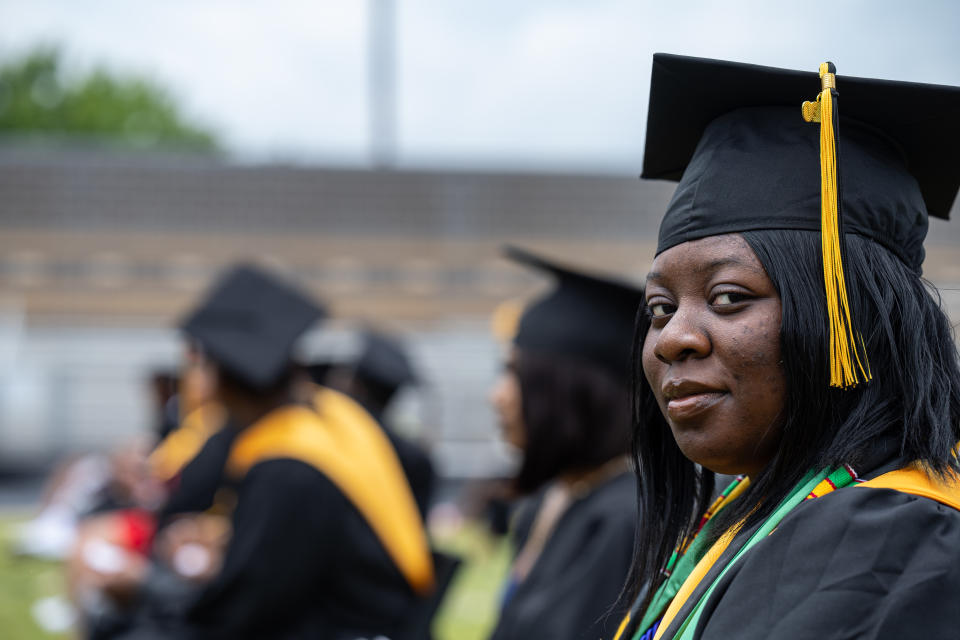 LOUISVILLE, KY - MAY 28: A former student of Jefferson County Public Schools grins and looks to the side while in cap and gown during a makeup graduation ceremony at Central High School on May 28, 2021 in Louisville, Kentucky. The makeup ceremony was held to celebrate the students whose graduations were disrupted due the coronavirus pandemic the previous year. (Photo by Jon Cherry/Getty Images)