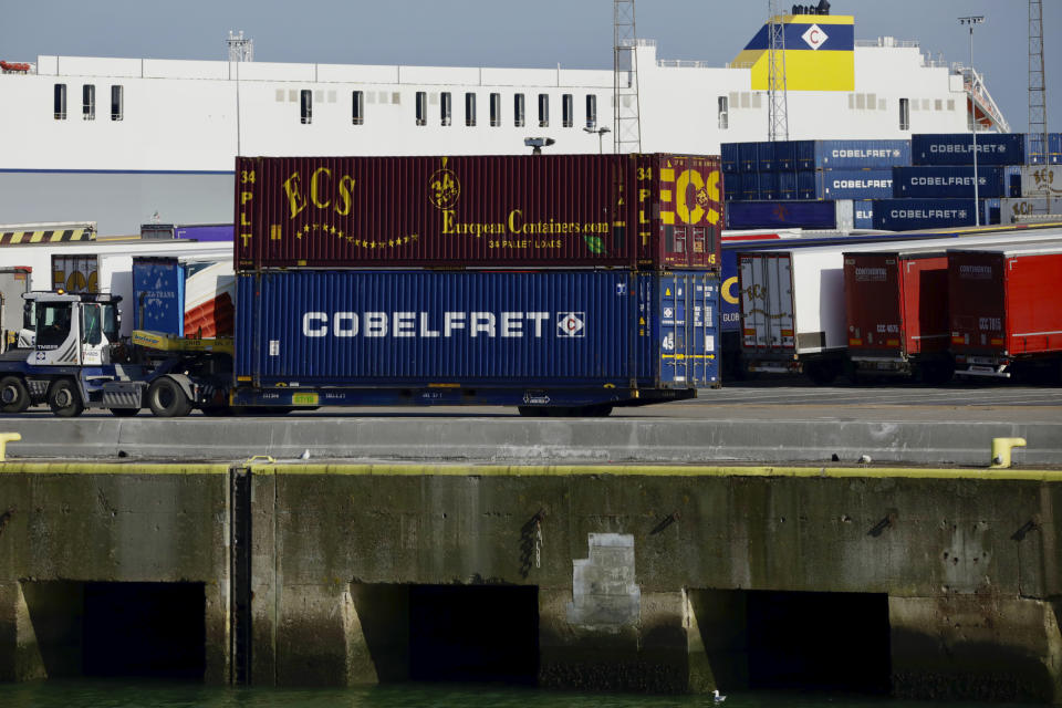 Shipping containers are moved and stacked as they are prepared load onto a ship at the Port of Zeebrugge, in Zeebrugge, Belgium, Thursday, Oct. 24, 2019. British police raided two sites in Northern Ireland and questioned a truck driver as they investigate the deaths of 39 people found in a truck container that they believe came from Zeebrugge and was found at an industrial park in southeastern England. (AP Photo/Olivier Matthys)