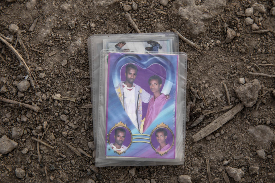 This July 15, 2019 photo shows old photographs which 28-year-old Abdel-Aziz Abdullah, a migrant from Ethiopia, carried in his wallet, in Obock, Djibouti. Over the past three years, the IOM reported 9,000 Ethiopians were deported each month. Many migrants have made the journey multiple times in what has become an unending loop of arrivals and deportations. (AP Photo/Nariman El-Mofty)