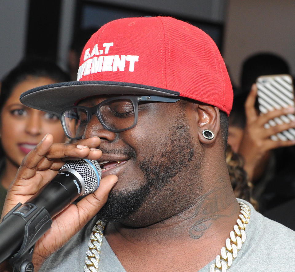 T-Pain with a microphone and showing his "Tattoo" tat