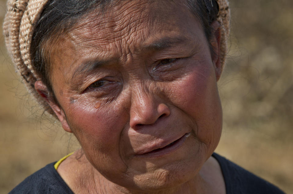 In this Jan 28 photo, Daw Li weeps before the graves of her two oldest sons, both victims of heroin overdoses, at Nampatka village cemetery, northeastern Shan State, Myanmar. In this village, roughly half the population uses heroin and opium. Residents once hoped new political and economic reforms sweeping their country would bring change to the wild hinterlands. Instead, many say their lives have only gotten worse as local authorities’ complicity and neglect have enabled a spiraling drug trade. (AP Photo/Gemunu Amarasinghe)