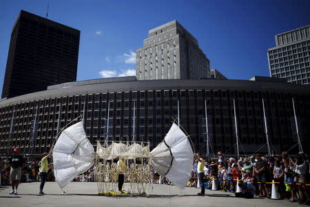 Onlookers watch a display of "Animaris Ordis," one from the series of "Strandbeests" kinetic sculptures by Dutch artist Theo Jansen, at City Hall Plaza in Boston, Massachusetts August 28, 2015. REUTERS/Brian Snyder