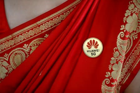 Huawei's logo is seen on a badge pinned on a saree of a lady at the India Mobile Congress in New Delhi