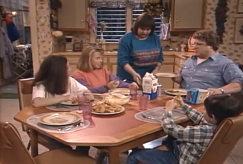 the family in "Roseanne" sitting down to a meal