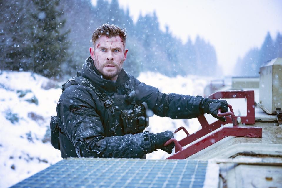 A man sits in the snow, looking at something off screen