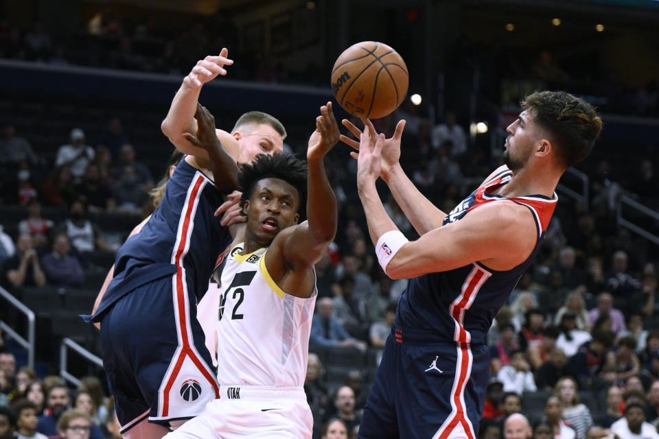 Utah Jazz guard Collin Sexton (2) vies for the ball against Washington Wizards forward Deni Avdija, right, and center Kristaps Porzingis, left, during the first half of an NBA basketball game Saturday, Nov. 12, 2022, in Washington. (AP Photo/Nick Wass)