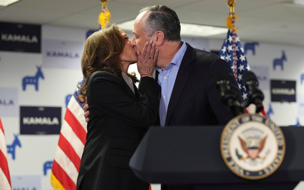 Kamala Harris, left, kisses second gentleman Doug Emhoff as she addresses staff at her campaign headquarters in Delaware