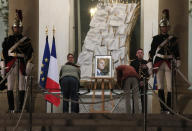People sign the condolences book to pay tribute to former President Jacques Chirac at the Elysee Palace, Thursday, Sept. 26, 2019. Jacques Chirac, a two-term French president who was the first leader to acknowledge France's role in the Holocaust and defiantly opposed the U.S. invasion of Iraq in 2003, has died Thursday at age 86. (AP Photo/Michel Euler)