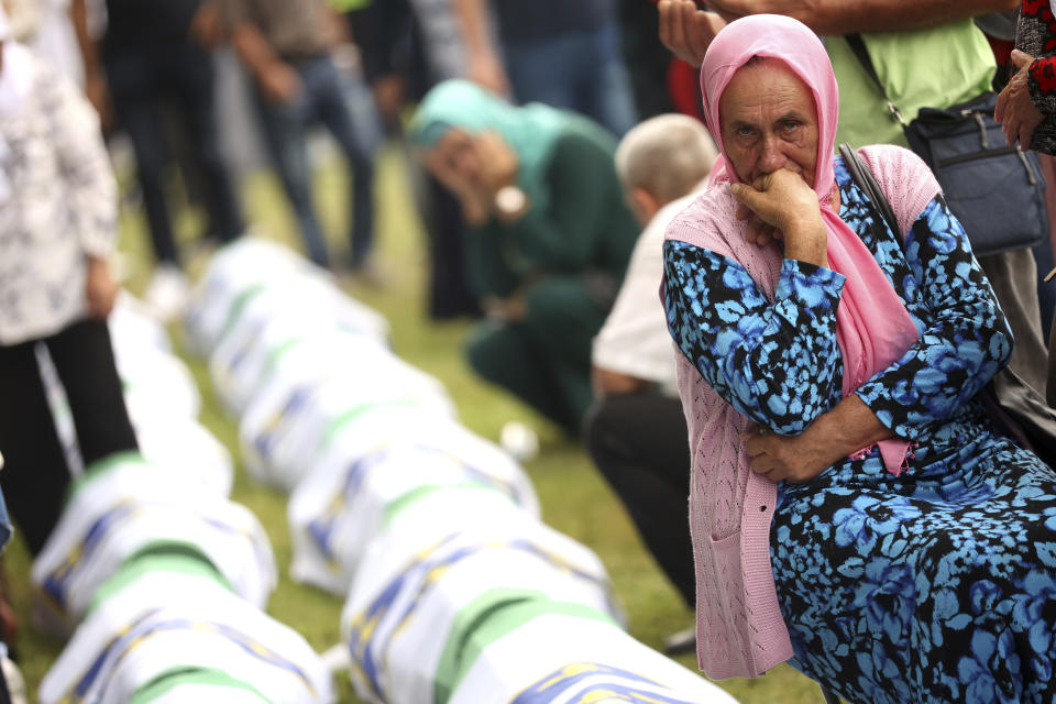 A Bosnian muslim woman mourns next to the coffin containing remains of her family member who is among 50 newly identified victims of the Srebrenica Genocide, in Potocari, Monday, July 11, 2022. Fifty newly identified victims were honored and reburied Monday in Bosnia as thousands gathered to commemorate the anniversary of the 1995 Srebrenica massacre, Europe’s only acknowledged genocide since the Holocaust. (AP Photo/Armin Durgut)