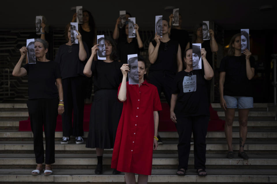 Relatives and supporters of Israeli hostages held by Hamas in Gaza hold photos of their loved ones during a performance calling for their return in Tel Aviv, Israel, Thursday, May 23, 2024. (AP Photo/Oded Balilty)